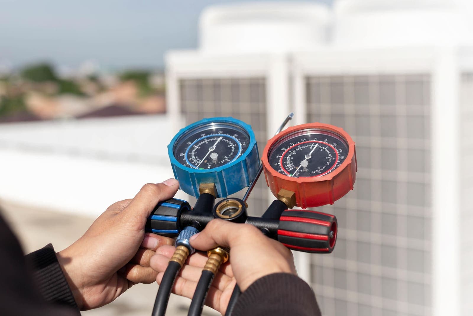 An HVAC technician checking an air conditioning system with gauges