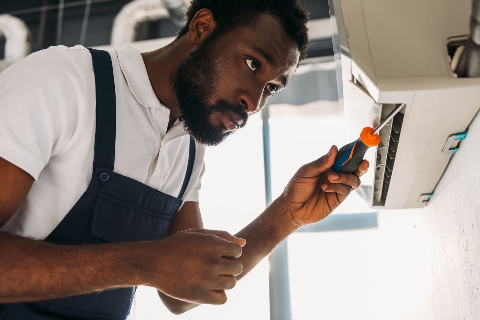 A technician repairing an air conditioning unit